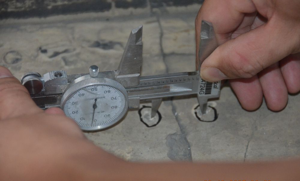 Dial caliper measuring a concrete crack